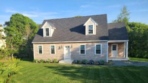 A lovely pink ADU with gray shingles on a well-manicured lawn